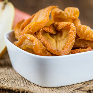 Wooden table with dried pears (selective focus; close up shot)