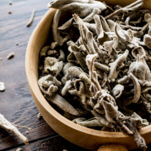 Dry sage tea in wooden ladle . organic food.
