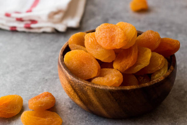 Dried apricots in wooden bowl. organic food.